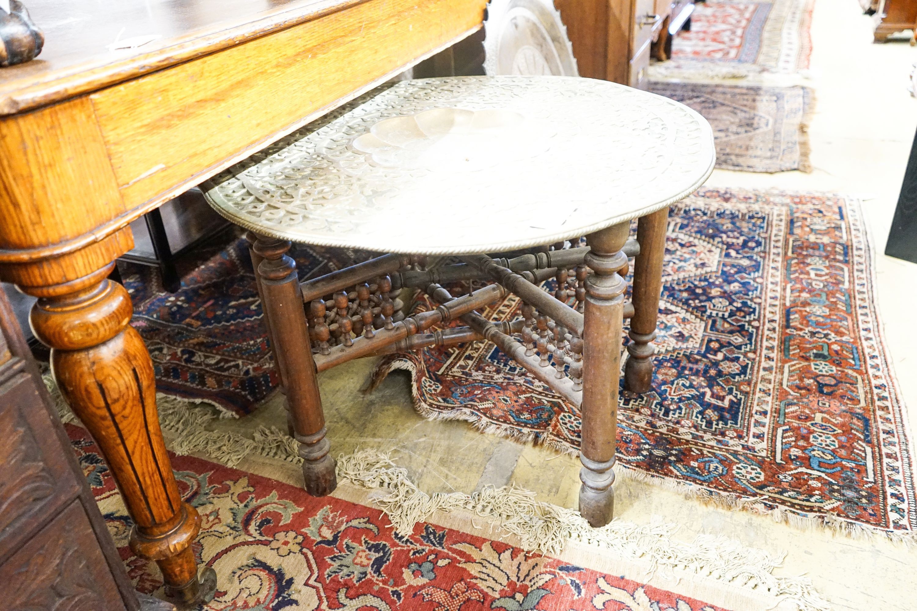 An Indian brass tray top table on folding stand, diameter 74cm, height 56cm together with a circular Indian brass tray